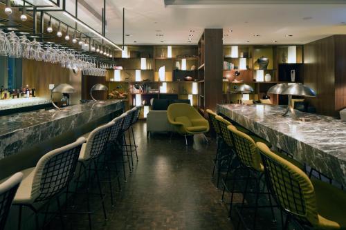 a bar in a restaurant with chairs and a counter at Hotel ICON in Hong Kong