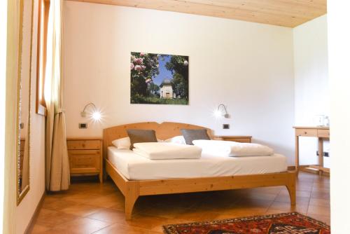 a bedroom with a bed with white sheets at Agritur Casteller in Trento