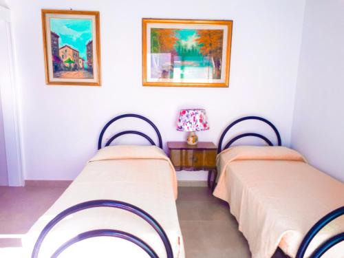 two beds in a room with paintings on the wall at TENERIFE LITTLE VILLAGE S in San Isidro