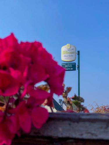 a sign with pink flowers in front of a building at Hotel Restaurant Denis in Zemmer