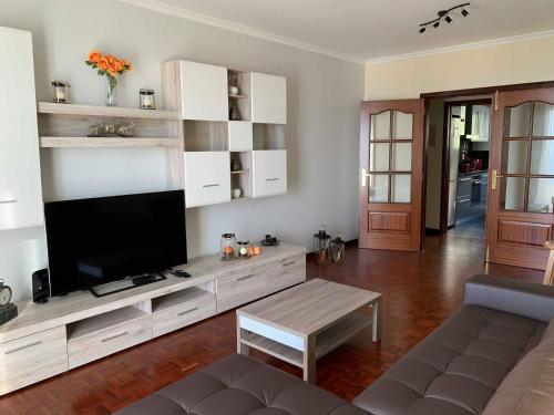 een woonkamer met een tv en een bank bij Ilha Atlântico in Caniço