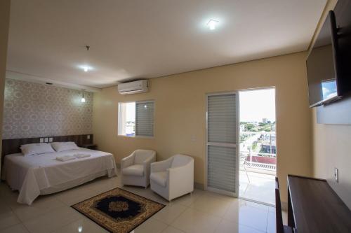 um quarto de hotel com uma cama e uma varanda em Garcia Palace Hotel em Sinop
