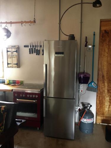 a kitchen with a stainless steel refrigerator and a stove at The Ruskamer Cottage at In the End in Stanford