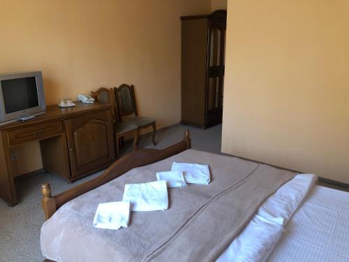 a bedroom with a bed with two towels on it at Chervona Gora in Mukacheve