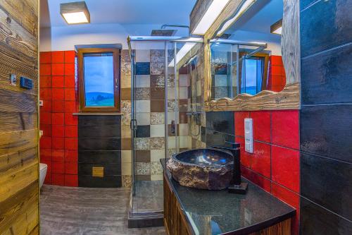 a bathroom with a sink and a red wall at Jaworczański Raj pod Wysoką - z Sauną przy Wyciągu in Szczawnica