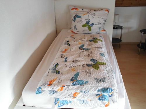 a bed with a white bedspread with butterflies on it at Ferienwohnung-Fuchs in Bad Schonborn