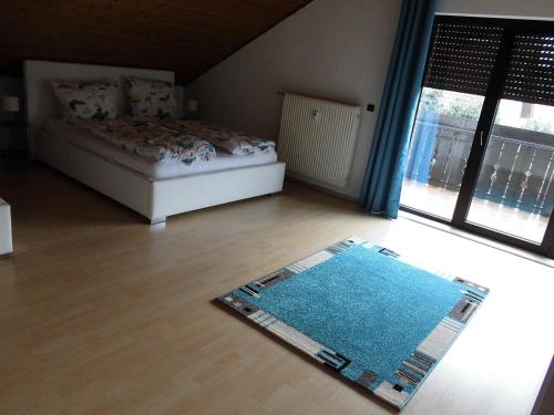 a bedroom with a bed and a rug on the floor at Ferienwohnung-Fuchs in Bad Schonborn