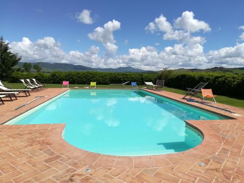 a large swimming pool with chairs at Agriturismo Piandimaggio in Pienza