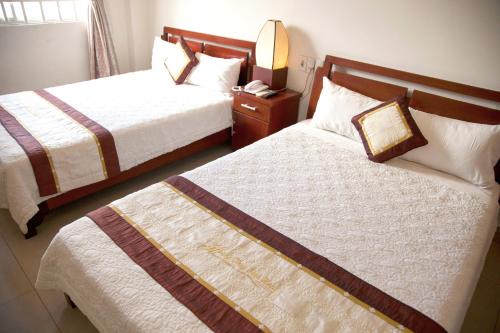 a hotel room with two beds and a telephone at Hoang Thuy Sinh Hotel in Da Nang