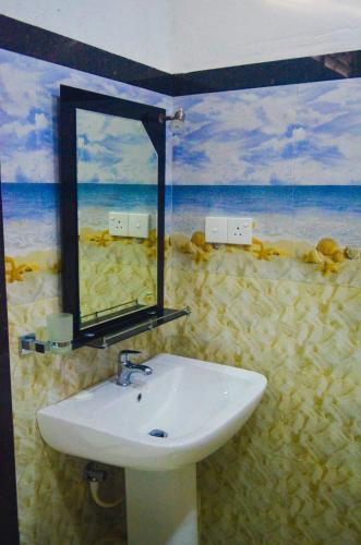 a bathroom with a sink and a mirror at Linda Cottage in Galle