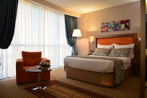 a hotel room with a bed and a chair at King Sky Tower Hotel in Batumi