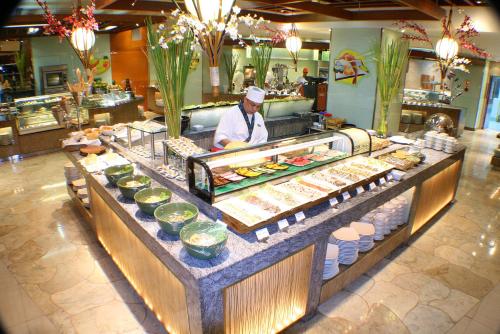a chef standing behind a buffet in a restaurant at Marco Polo Plaza Cebu in Cebu City