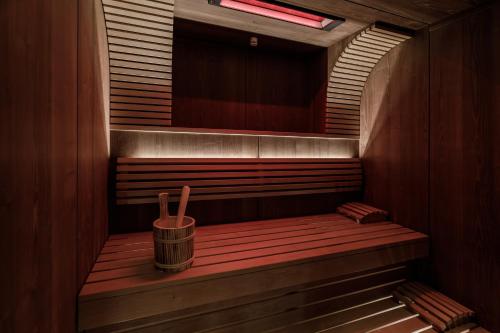 a sauna with a trash can on a wooden bench at Cocoon - Alpine Boutique Lodge in Maurach