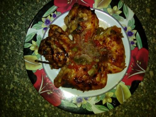 a plate of food with chicken with sauce on it at Pharaohs Hotel in Luxor