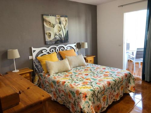 1 dormitorio con 1 cama con colcha colorida en Apartamento playa arinaga en Arinaga