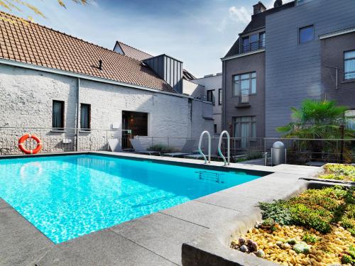 een zwembad in de achtertuin van een huis bij Hotel Harmony in Gent