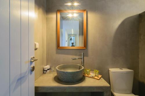 a bathroom with a sink and a toilet at L’arco Milos Suite in Adamas