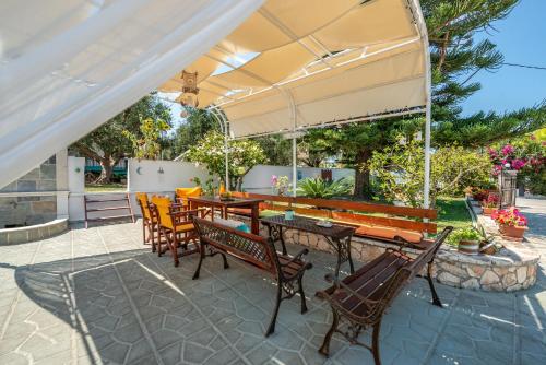 a patio with a table and chairs under an umbrella at Panorama Studios & Apartments in Amoudi