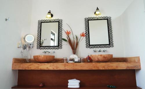 a bathroom with two sinks and a mirror at Merida Santiago Hotel Boutique in Mérida
