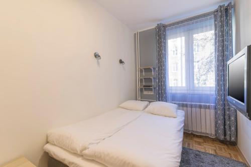 a small bedroom with a bed and a window at TriApart Cozy in Gdańsk