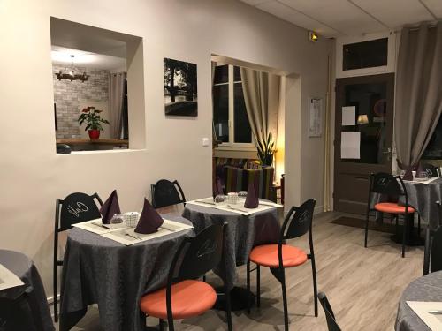 - une salle à manger avec des tables, des chaises et un miroir dans l'établissement HÔTEL LES IRIS, aux Andelys