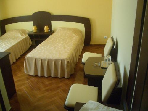 Habitación de hotel con 2 camas, mesa y sillas en Maria, en Eforie Sud