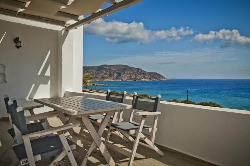 a table and chairs on a balcony with a view of the ocean at Alsalos villas in Amoopi