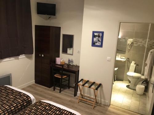 een slaapkamer met een badkamer met een toilet en een wastafel bij HÔTEL LES IRIS in Les Andelys