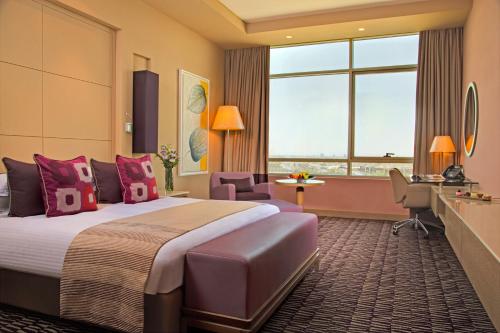 a hotel room with a large bed and a desk at Erbil Rotana in Erbil