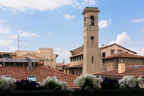 um edifício com uma torre de relógio no topo de um telhado em Mabelle Firenze Residenza Gambrinus em Florença