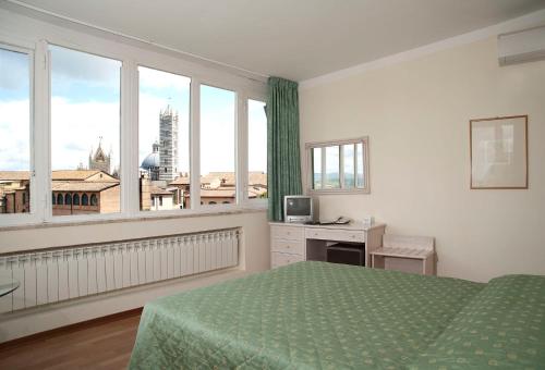 a bedroom with a bed and a large window at Hotel Duomo in Siena