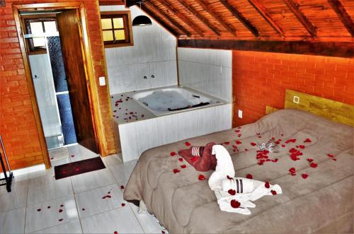 a bedroom with a bed with roses on the floor at Chales Fazenda Cantinho do Selado in Monte Verde