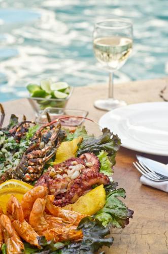 a plate of food with shrimp and a glass of wine at Bungalows Zicatela in Puerto Escondido