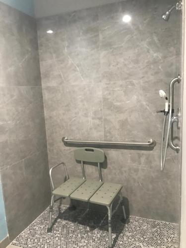 a shower with a bench in a bathroom at The Residency Suites in Houston
