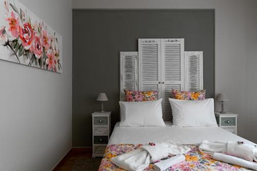 1 dormitorio con 1 cama con sábanas y almohadas blancas en Athens Flower Apartment, en Atenas