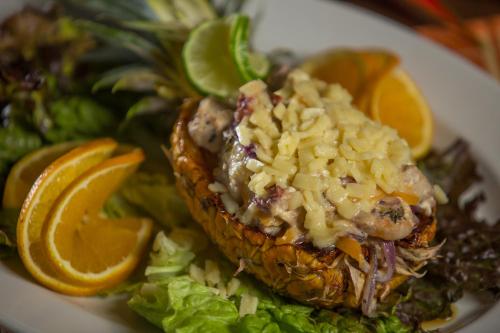 a plate of food with a pineapple with dressing on it at Bungalows Zicatela in Puerto Escondido