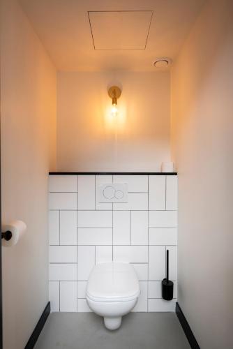 a bathroom with a toilet with a light on the ceiling at Hotel the Match in Eindhoven