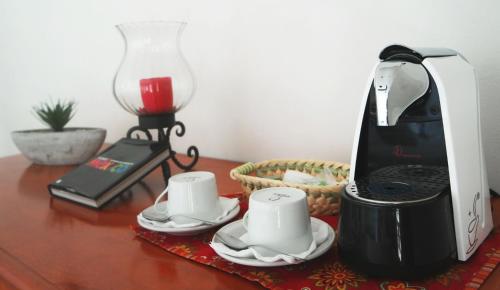 a coffee maker and two cups on a table at Merida Santiago Hotel Boutique in Mérida