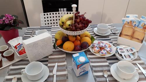 Le note dei Sassi Holiday Home في ماتيرا: طاولة مع وعاء من الفاكهة ووعاء من الحليب