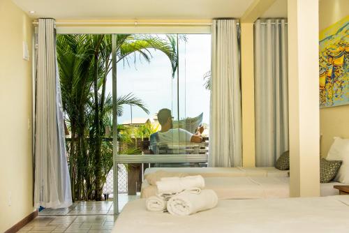 a room with a bed and a window with towels at Pousada La Dolce Vita in Búzios