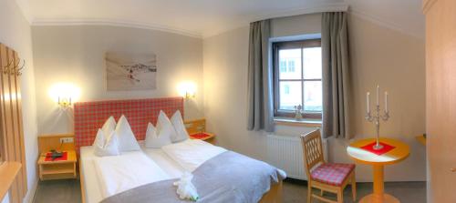 a hotel room with a bed and a window at Andi's Skihotel in Obertauern