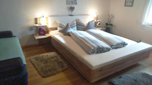 a bedroom with a large bed with pillows on it at Apartment Greidlerhof in Rohrberg