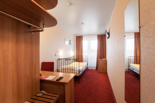 a hotel room with two beds and a desk at Okhtinskaya Hotel in Saint Petersburg