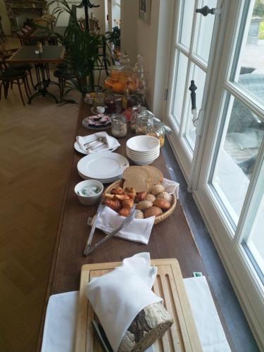 a table with food on it in a room with windows at Hotel Kronacker in Tienen