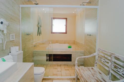 a bathroom with a tub and a toilet and a sink at Pousada La Dolce Vita in Búzios