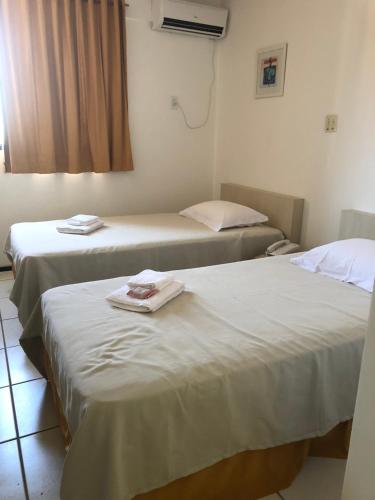 Dos camas en una habitación de hotel con toallas. en Melo Hospedagem - Flat Bellagio, en São Luís