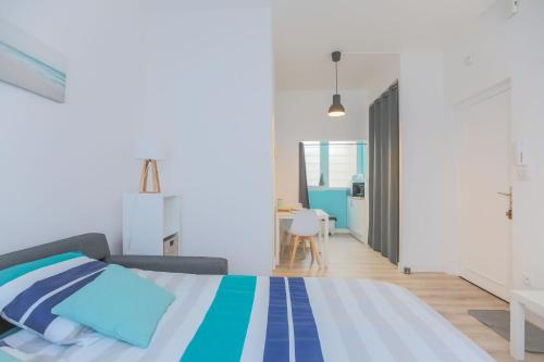 sypialnia z łóżkiem z niebieskimi i białymi paskami w obiekcie studio marine 100m plage w mieście Royan