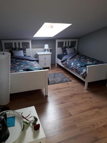 a bedroom with two beds and a table and a window at NaNoc - noclegi obok lubelskich szpitali i centrum Lublina in Lublin