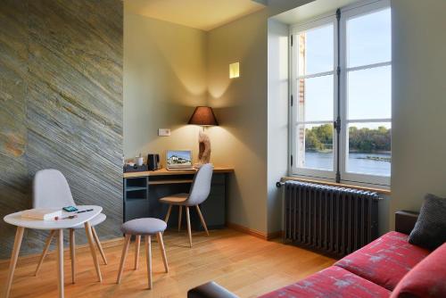 a living room with a couch and a table at Suites du Cabinet Vert in Orléans