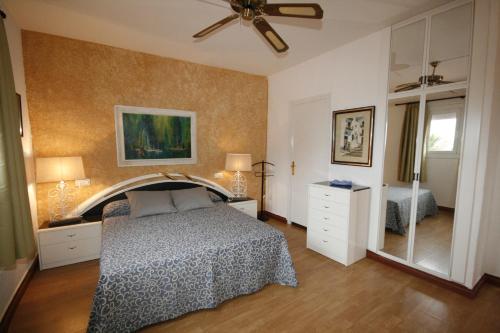 Schlafzimmer mit einem Bett und einem Deckenventilator in der Unterkunft Ciudad De Vacaciones Cala Montjoi in Roses
